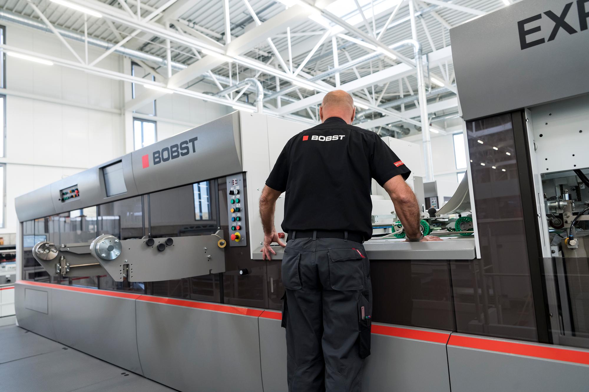 Un employe de l'entreprise Bobst inspecte une machine de decoupe de carton dans le centre de competence du Groupe Bobst a l'occasion de la presentation des resultats de l'exercice 2018 du Groupe Bobst ce mercredi 27 fevrier 2019 a Mex. (KEYSTONE/Jean-Christophe Bott)
