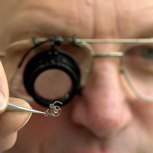 Un horloger de la firme Patek Philippe travaille sur un tourbillon de montre, lors du reportage a la manufacture horlogere Patek Philippe de Plan-les-Ouates Geneve, ce 11 novembre 2005. (KEYSTONE/Sandro Campardo) Ein Uhrmacher der Firma Patek Philippe arbeitet an einer Uhr, aufgenommen anlaesslich einer Reportage in der Uhrenmanufaktur in Plan-les-Ouates in Genf am 11. November 2005. Patek Philippe wurde 1839 von zwei polnischen Immigranten gegruendet und ist eine unabhaengige und sich in Familienbesitz befindende Firma, die als einzige Uhrenmanufaktur alle ihre mechanischen Teile gemaess den strengen Bestimmungen des Genfer Siegels selbst produziert. Patek Philippe umfasst die Hauptproduktionsstaette, den Hauptsitz, die Gehaeuse- und Armbandproduktionsstaetten und das Museum in verschiedenen Quartieren in Genf, sowie Patek Philippe Salons in Genf, Paris und London. (KEYSTONE/Sandro Campardo) A watchmaker of the Patek Philippe company works on a watch, pictured on the occasion of a reportage in the watch manufacture in Plan-les-Ouates in Geneva, Switzerland, pictured on November 2005. Patek Philippe was founded in 1839 by two Polish immigrants and is an independent and family owned company. It is the only watch manufacture that crafts all its mechanical movements according to the strict specifications of the Geneva Seal. Patek Philippe includes the main workshops and headquarters, the case and bracelet workshops and the museum in Geneva, as well as Patek Philippe Salons in Geneva, Paris and London. (KEYSTONE/Sandro Campardo)