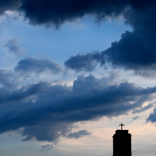 Des nuages et le ciel au soleil couchant sont photographies en dessus du clocher de l' Eglise rouge ce samedi 27 mai 2017 a Neuchatel. (KEYSTONE/Laurent Gillieron)
