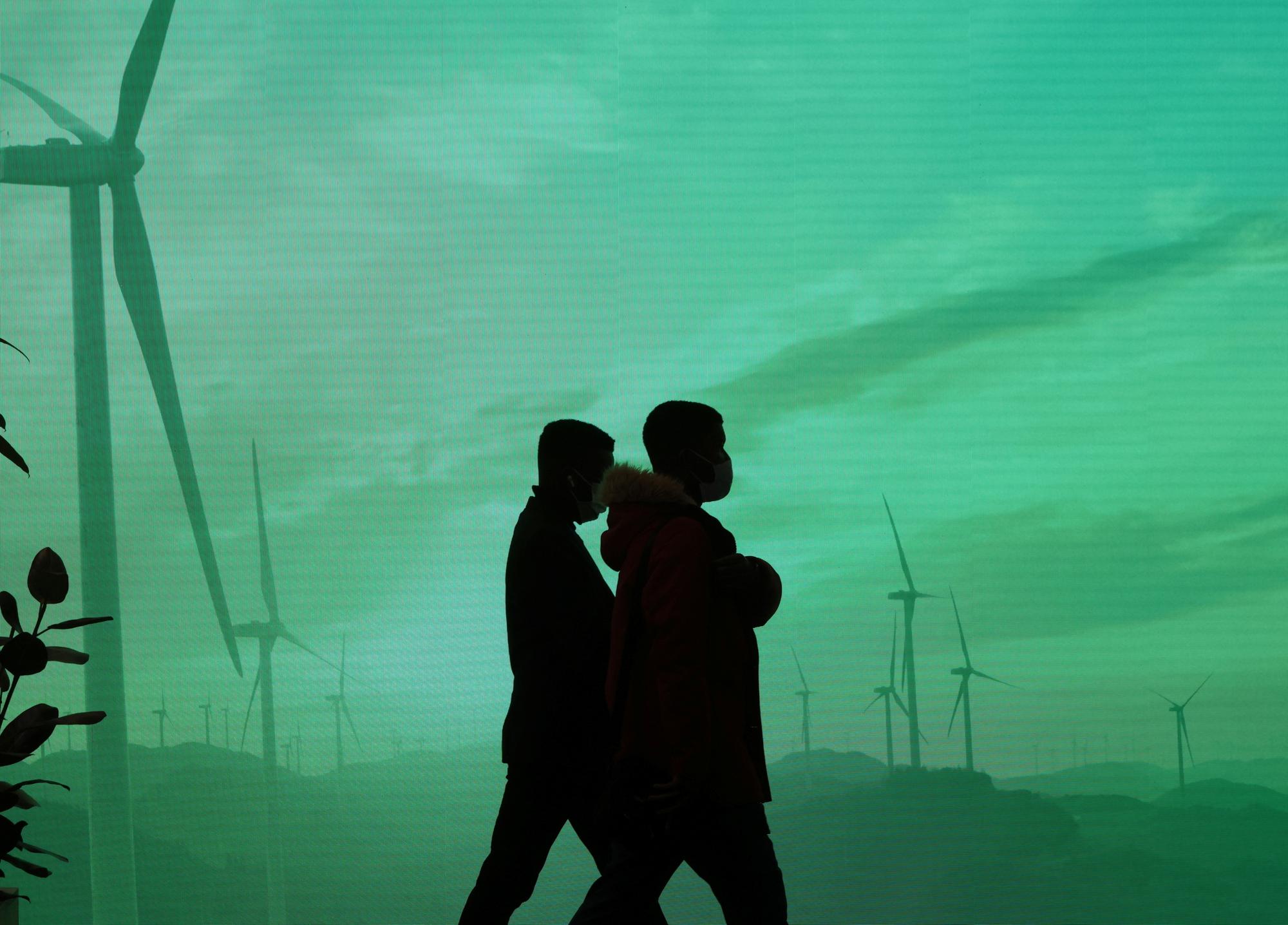 Des délégués passent devant un écran dans le centre de conférences qui accueille la COP26, à Glasgow, le 1er novembre 2021.