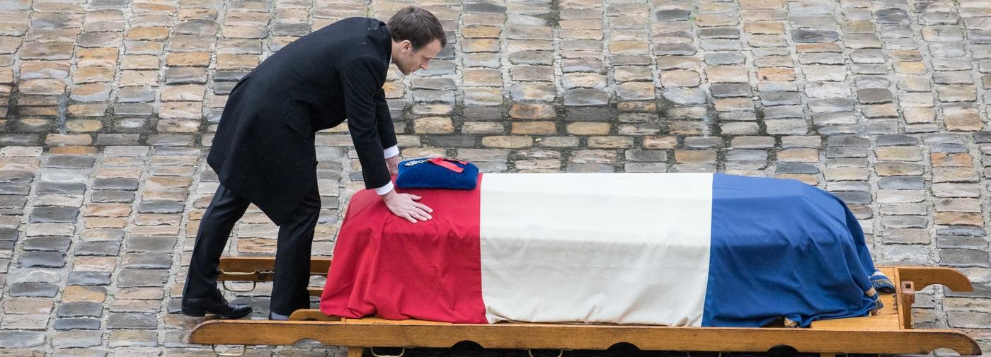 Emmanuel Macron face à un cercueil recouvert du drapeau tricolore dans la cour des Invalides en 2018.