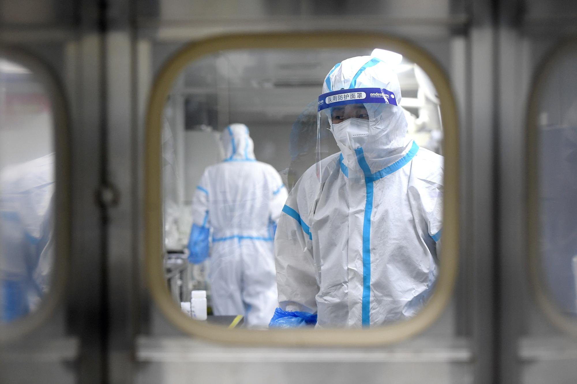 Le personnel médical en combinaison de protection teste des échantillons au laboratoire BGI de Huo-Yan après l'identification de nouveaux cas de Covid-19. Wuhan, le 5 août 2021.