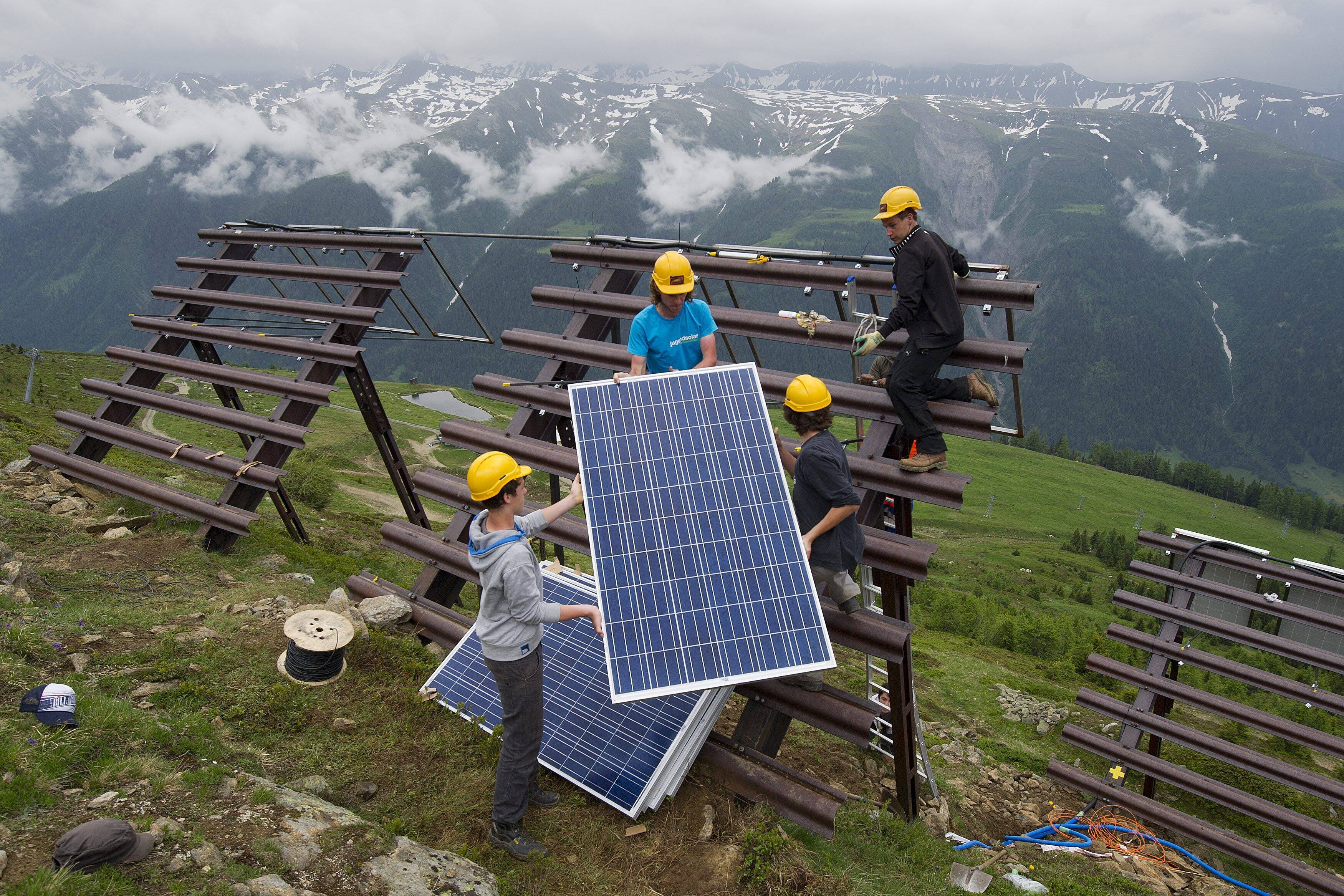 image d'illustration: Des jeunes posent des panneaux solaires ou panneaux photovoltaiques sur des paravalanches, le 20 juin 2012, à Bellwald dans la Vallée de Conches, Haut-Valais.