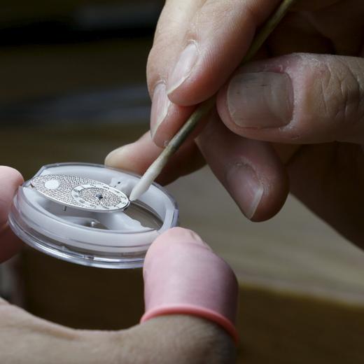 Un horloger travaillant le cadran d'une montre.