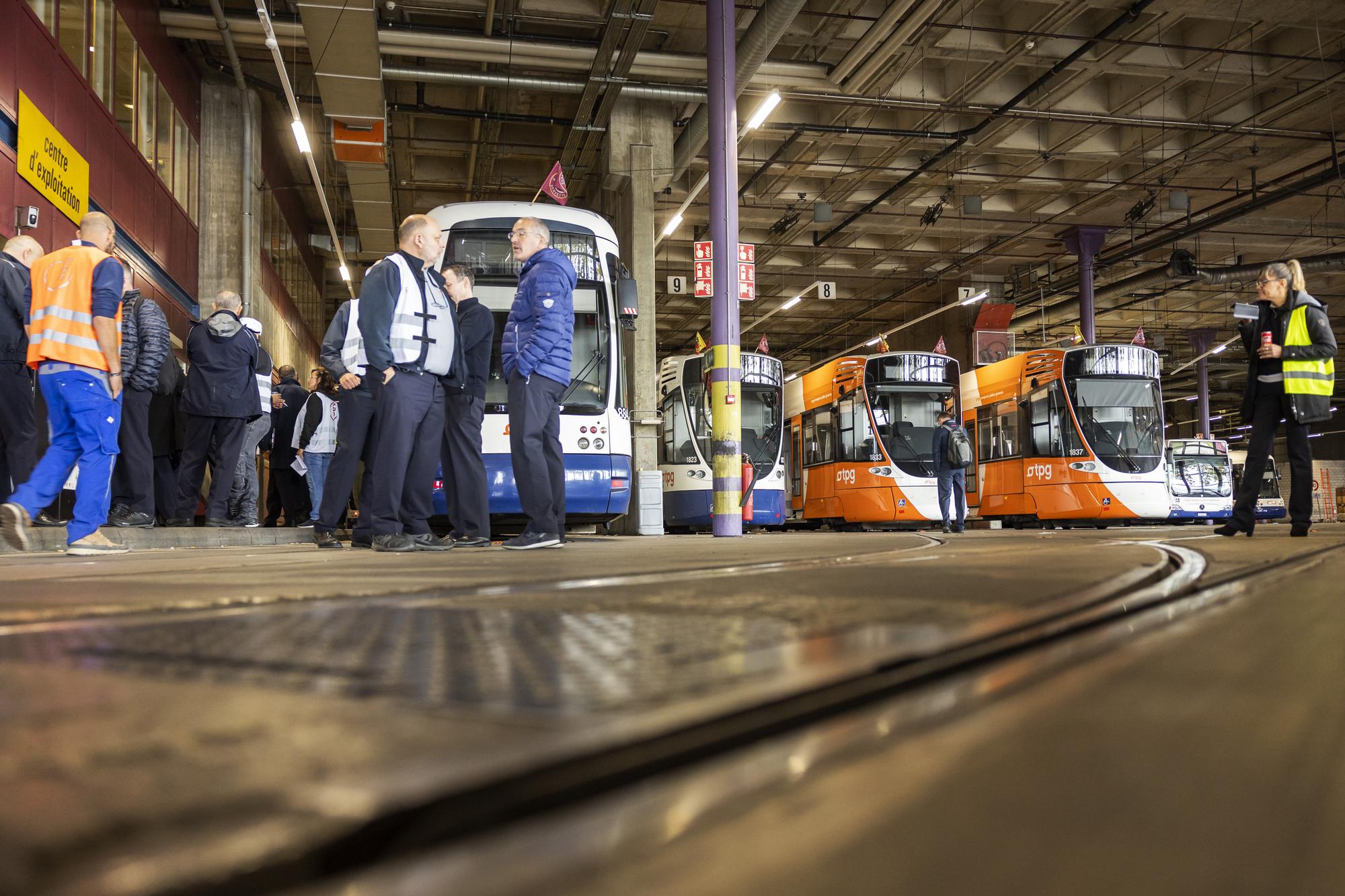 Des employes grevistes font un piquet de greve au depot du Bachet, lors de la journee de greve du personnel des Transports publics genevois (TPG), ce mercredi 12 octobre 2022 a Geneve. A l'appel du Syndicat du personnel des transports (SEV) et de Transfair, une partie du personnel des Transports publics genevois (TPG) est en greve pour demander l'indexation entiere du rencherissement, soit 1,2%, depuis le debut de l'annee.. (KEYSTONE/Salvatore Di Nolfi)