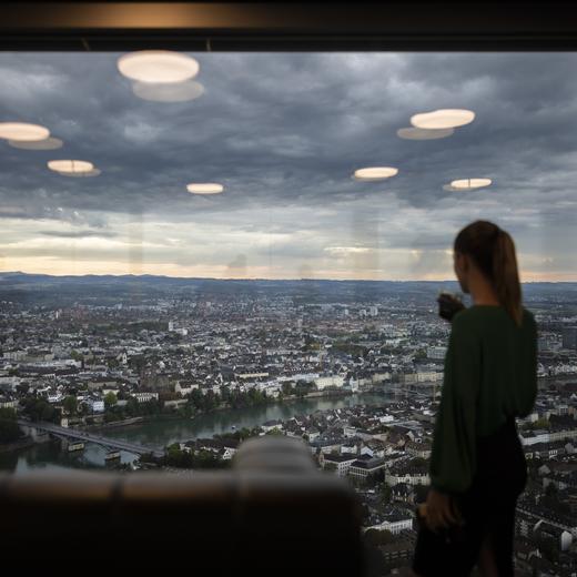 Eine Frau schaut aus dem Fenster des 47. Stockwerks des Roche-Turm Bau 2, aufgenommen anlaesslich der Eroeffnung, Freitag, 2. September 2022, am Hauptsitz der Roche in Basel. Der 205 Meter hohe Roche Turm Bau 2 des Schweizer Pharmaunternehmens Roche Holding AG ist das hoechste Hochhaus der Schweiz und wird auf 50 Etagen Platz fuer rund 3200 Arbeitsplaetze bieten. (KEYSTONE/Michael Buholzer)