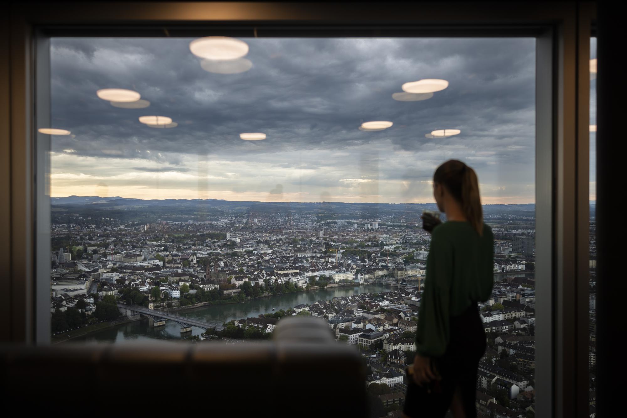 Eine Frau schaut aus dem Fenster des 47. Stockwerks des Roche-Turm Bau 2, aufgenommen anlaesslich der Eroeffnung, Freitag, 2. September 2022, am Hauptsitz der Roche in Basel. Der 205 Meter hohe Roche Turm Bau 2 des Schweizer Pharmaunternehmens Roche Holding AG ist das hoechste Hochhaus der Schweiz und wird auf 50 Etagen Platz fuer rund 3200 Arbeitsplaetze bieten. (KEYSTONE/Michael Buholzer)