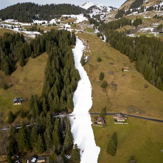 Une piste de neige artificielle au milieu d'un champ sans neige, à 1600 mètres d'altitude, dans la station alpine de Villars-sur-Ollon, en Suisse, le 31 décembre 2022.