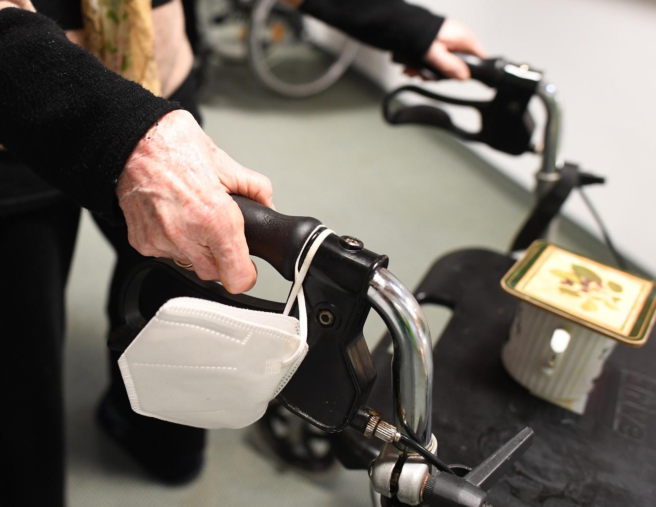 ARCHIV - 05.11.2021, Bayern, Garmisch-Partenkirchen: Eine Heimbewohnerin schiebt ihren Rollator mit FFP-2 Maske durch einen Gang in einem Altersheim. Laut Berechnungen des Statistischen Bundesamtes gibt es bis 2035 etwa vier Millionen mehr Menschen im Alter ab 67 Jahren. (zu dpa «Experten: Zukünftig mehr Senioren und Pflegebedarf in Deutschland») Foto: Angelika Warmuth/dpa +++ dpa-Bildfunk +++ (KEYSTONE/DPA/Angelika Warmuth)