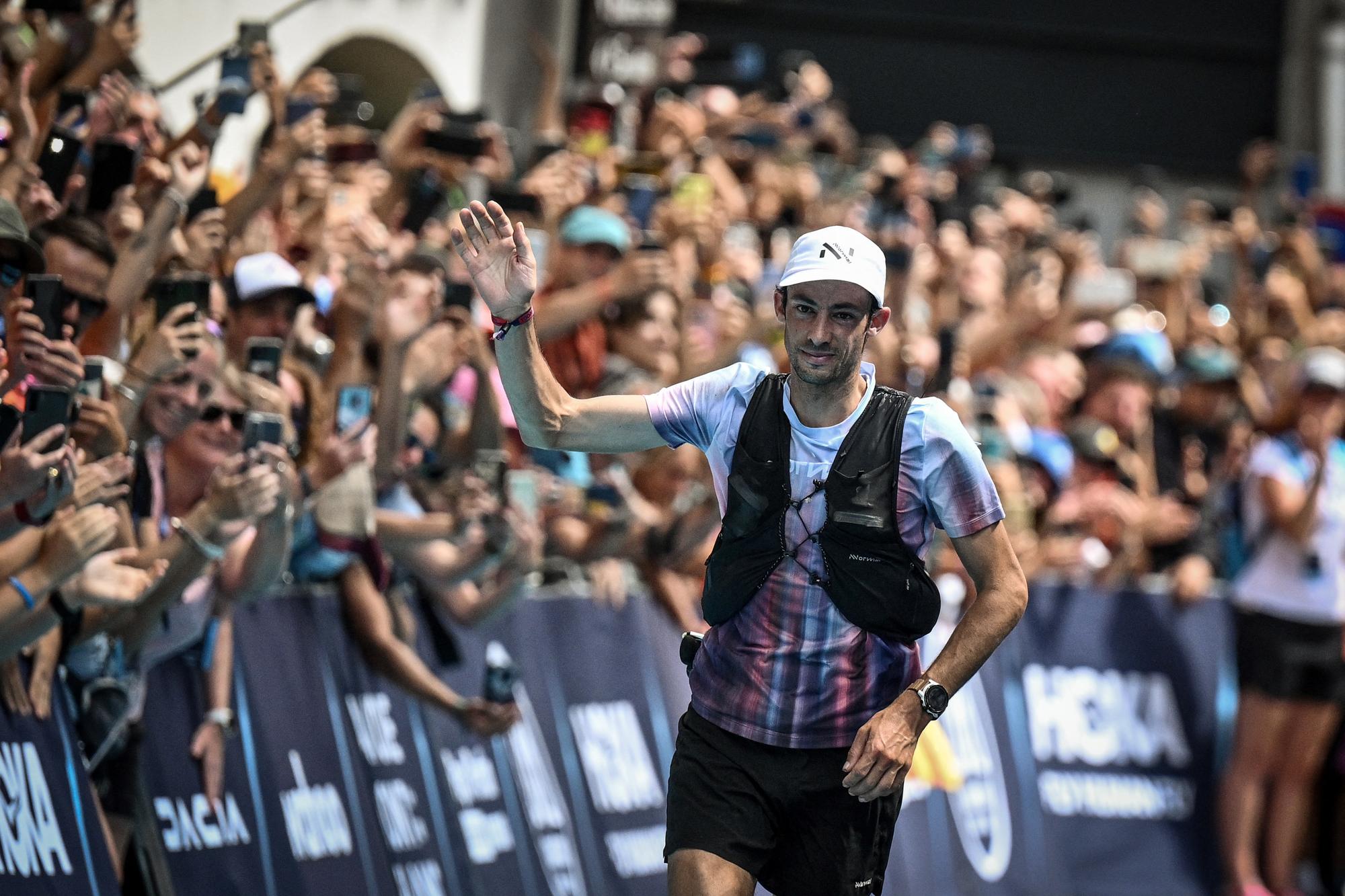 Spain's Kilian Jornet celebrates as he crosses the finish line and wins the 19th edition of the Ultra Trail du Mont Blanc (UTMB) a 171km trail race crossing France, Italy and Switzerland in Chamonix, south-eastern France on August 27, 2022. - The Spanish ultra trail star Kilian Jornet was victorious in the fourth Ultra-Trail du Mont-Blanc (UTMB) of his career, setting a new record time of under twenty hours. (Photo by JEFF PACHOUD / AFP)