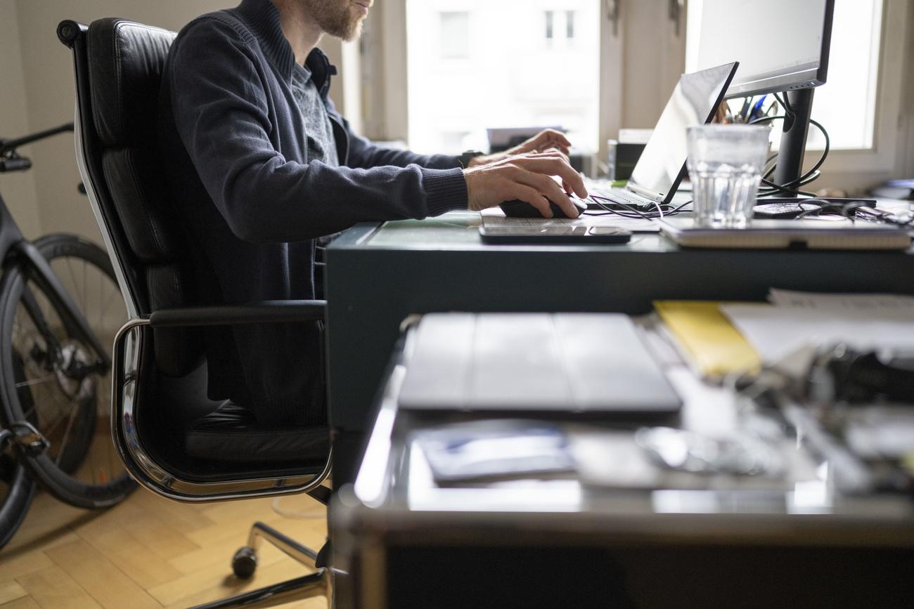 Ein Mann arbeitet mit Laptop und Bildschirm im Homeoffice, fotografiert am Mittwoch, 5. Januar 2022 in Zuerich. (KEYSTONE/Christian Beutler)