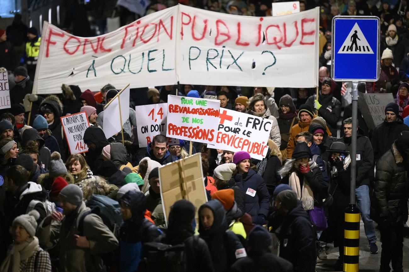 Des employes de l'Etat de Vaud brandissent des pancartes lors de la manifestion qui fait suite a la journee d'actions et de greve de la fonction publique vaudoise, des salaries des secteurs publics a l'appel de leurs syndicats (FSF, SSP, SUD) ce lundi 23 janvier 2023 a Lausanne. (KEYSTONE/Laurent Gillieron)