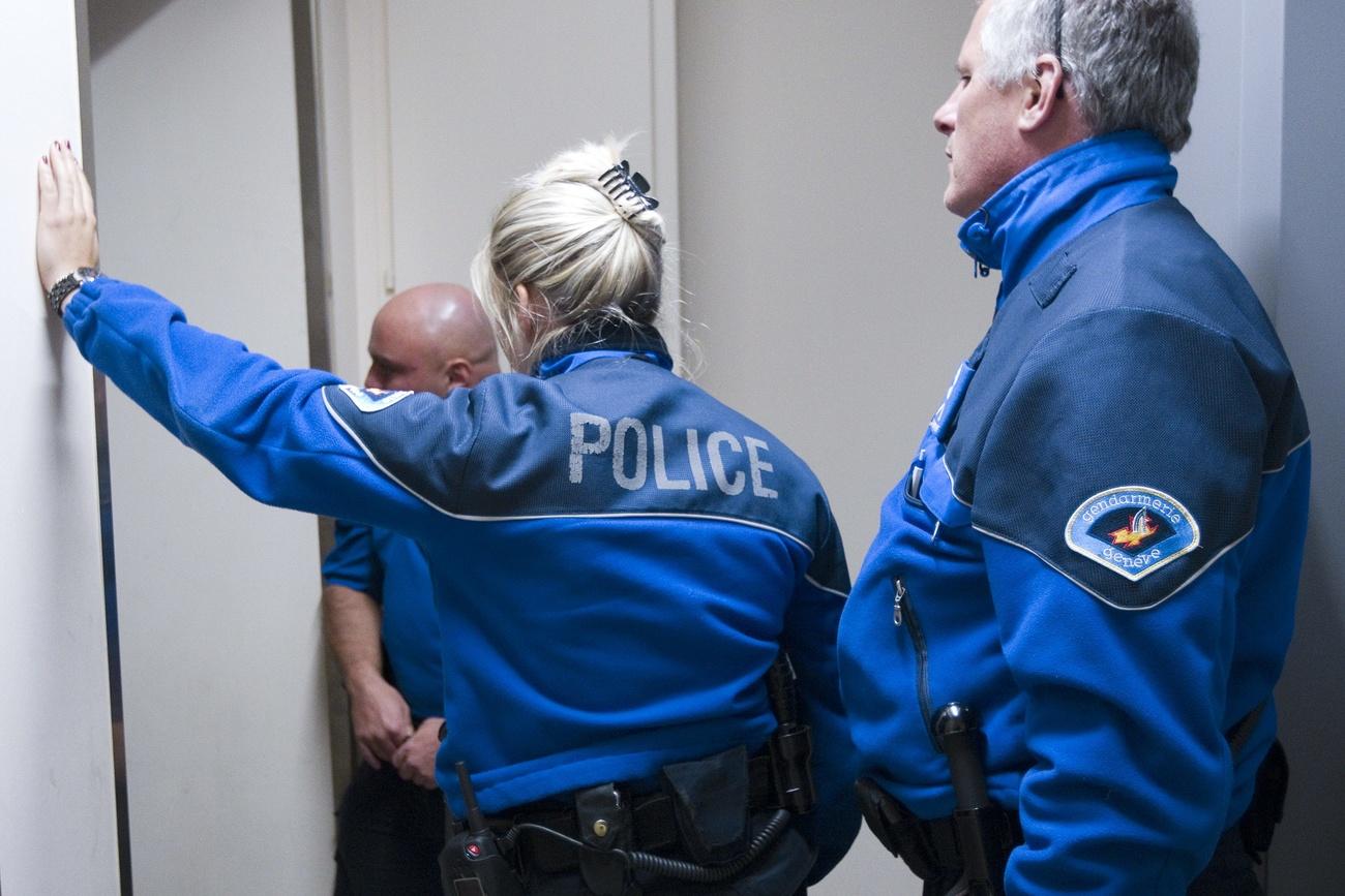 Des gendarmes de la police genevoise parle avec une femme concernant une possible violence domestique suite a l'appel d'un voisin, ce mercredi 1 septembre 2010 a Geneve. (KEYSTONE/Salvatore Di Nolfi)