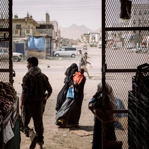 In this image released by the World Press Photo Foundation Thursday April 11, 2019, titled "Yemen Crisis" by Lorenzo Tugnoli, Contrasto, for The Washington Post, which was awarded first prize in the General News, Stories, category, shows a woman begging outside a grocery store in Azzan, a pivotal southern crossroads town that had seesawed back and forth between government and insurgent forces in Yemen, on 22 May 2018. (Lorenzo Tugnoli, Contrasto, for The Washington Post, World Press Photo via AP)