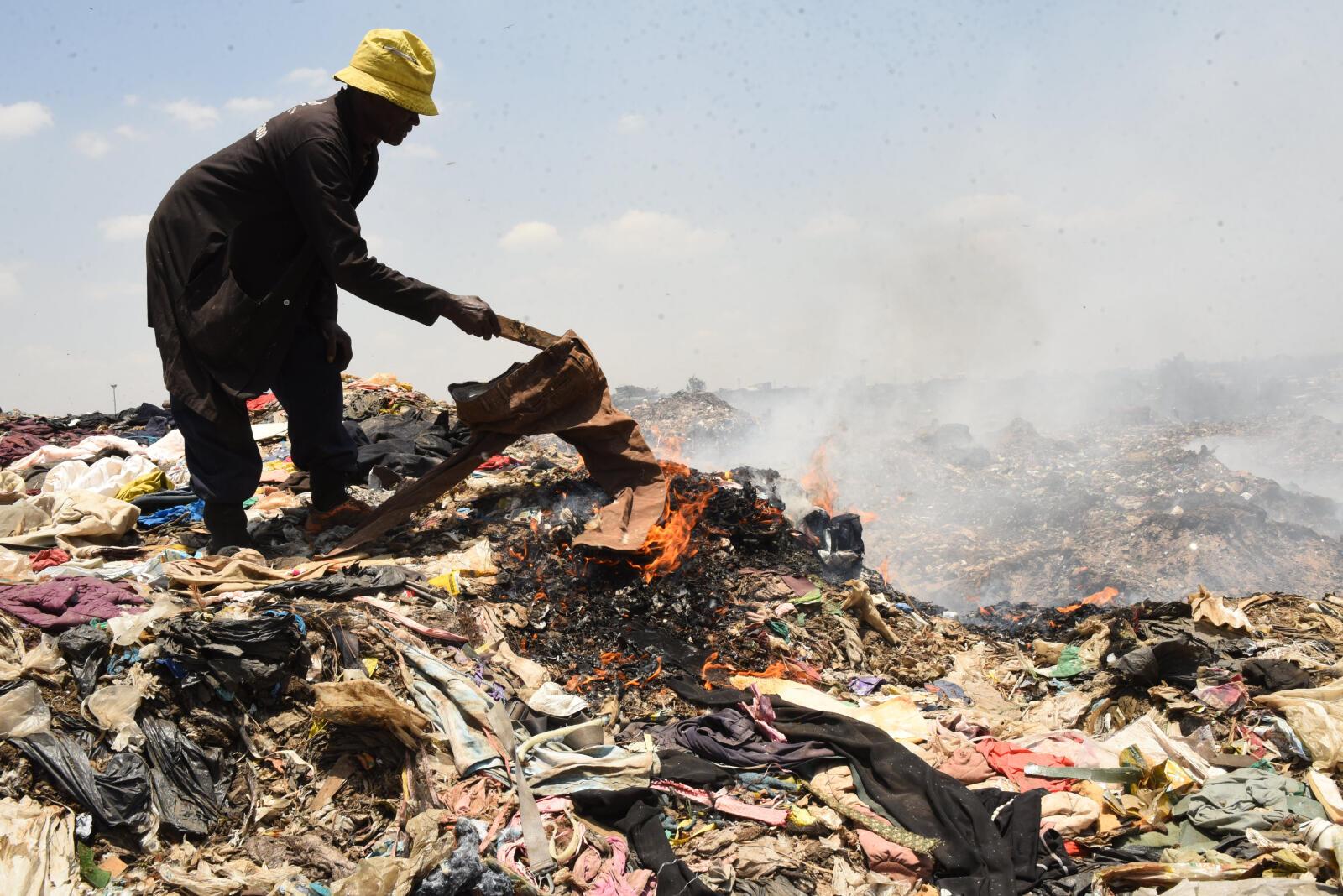 A man burns linen at Dandora dump site in Nairobi city on September 19,2022.