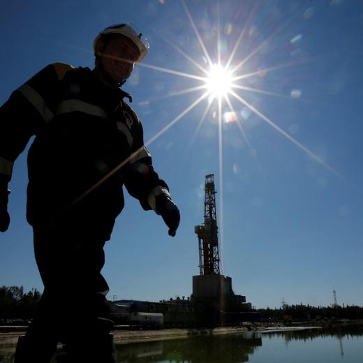 FILE PHOTO: A worker walks past a drilling rig at a well pad of the Rosneft-owned Prirazlomnoye oil field outside the West Siberian city of Nefteyugansk, Russia, August 4, 2016. Picture taken August 4, 2016. REUTERS/Sergei Karpukhin/File Photo