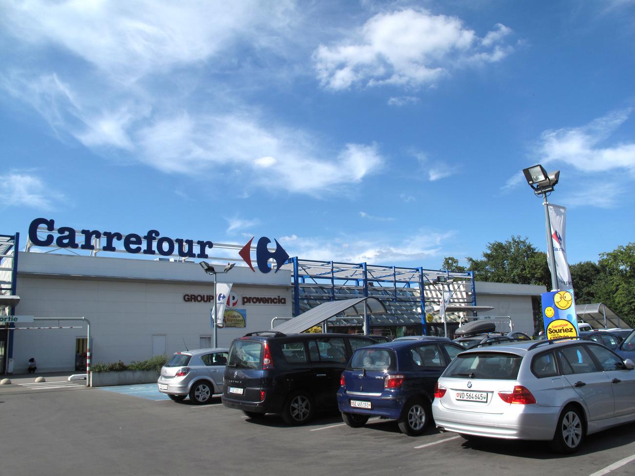 This picture taken Aug. 13, 2011 shows the Carrefour supermarket in Ferney-Voltaire, France where Swiss license plates are prevalent in the parking lot just over the border from Geneva. The Swiss are taking advantage of the strong franc to buy in the Eurozone. (AP Photo/John Heilprin)