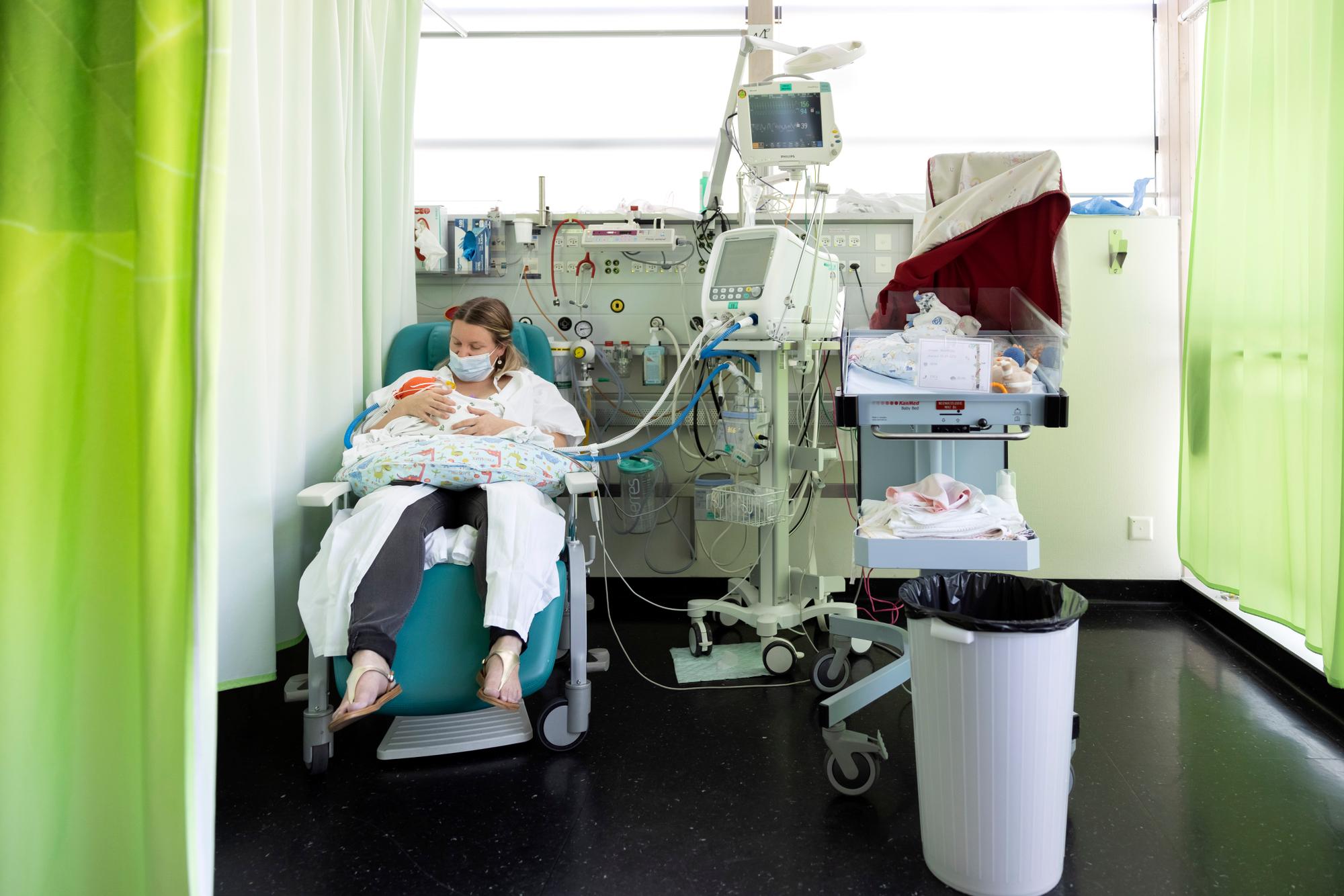 Une maman tient son bebe dans ses bras au service de neonatologie lors de la conference de presse sur la premiere banque de lait maternel (lactarium) de Suisse romande ce jeudi, 2 septembre 2021 au Centre hospitalier universitaire vaudois (CHUV) a Lausanne. (KEYSTONE/Cyril Zingaro)