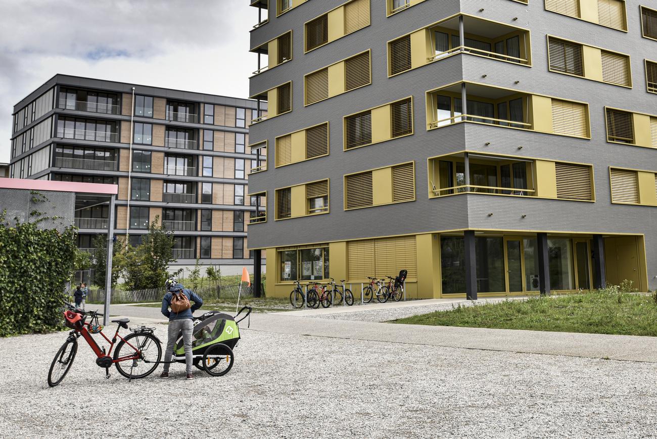 Une personne se tient devant un batiment de l'eco-quartier des Vergers ce lundi 28 septembre 2020 a Meyrin. Un nouveau projet alimentaire, "La Feve" verra le jour dans ce quartier nouvellement construit des environs de Geneve. (KEYSTONE/Theophile Bloudanis)