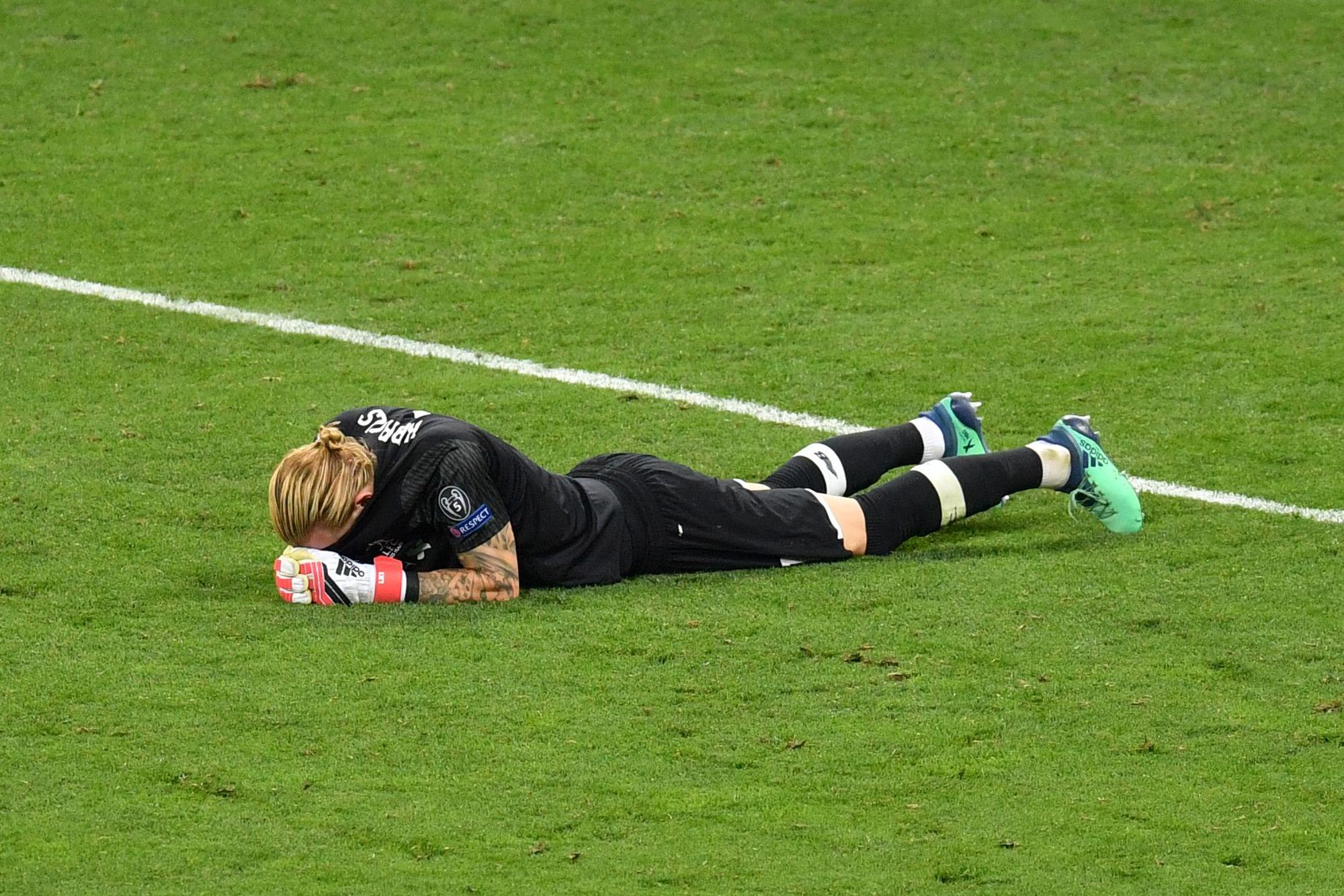 TOPSHOT - Liverpool's German goalkeeper Loris Karius lays on the pitch after the UEFA Champions League final football match between Liverpool and Real Madrid at the Olympic Stadium in Kiev, Ukraine on May 26, 2018 / AFP PHOTO / Sergei SUPINSKY