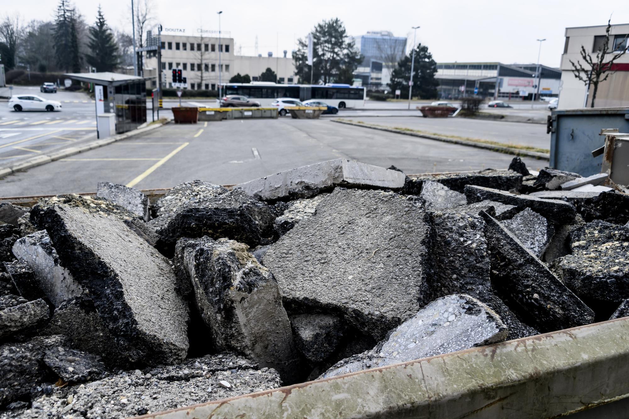 Des bennes de chantier sont installe comme une barricade devant l'entree d'un parking afin d'empecher l'installation des caravanes des gens du voyage le samedi 4 mars 2023 a Bussigny. (KEYSTONE/Jean-Christophe Bott)