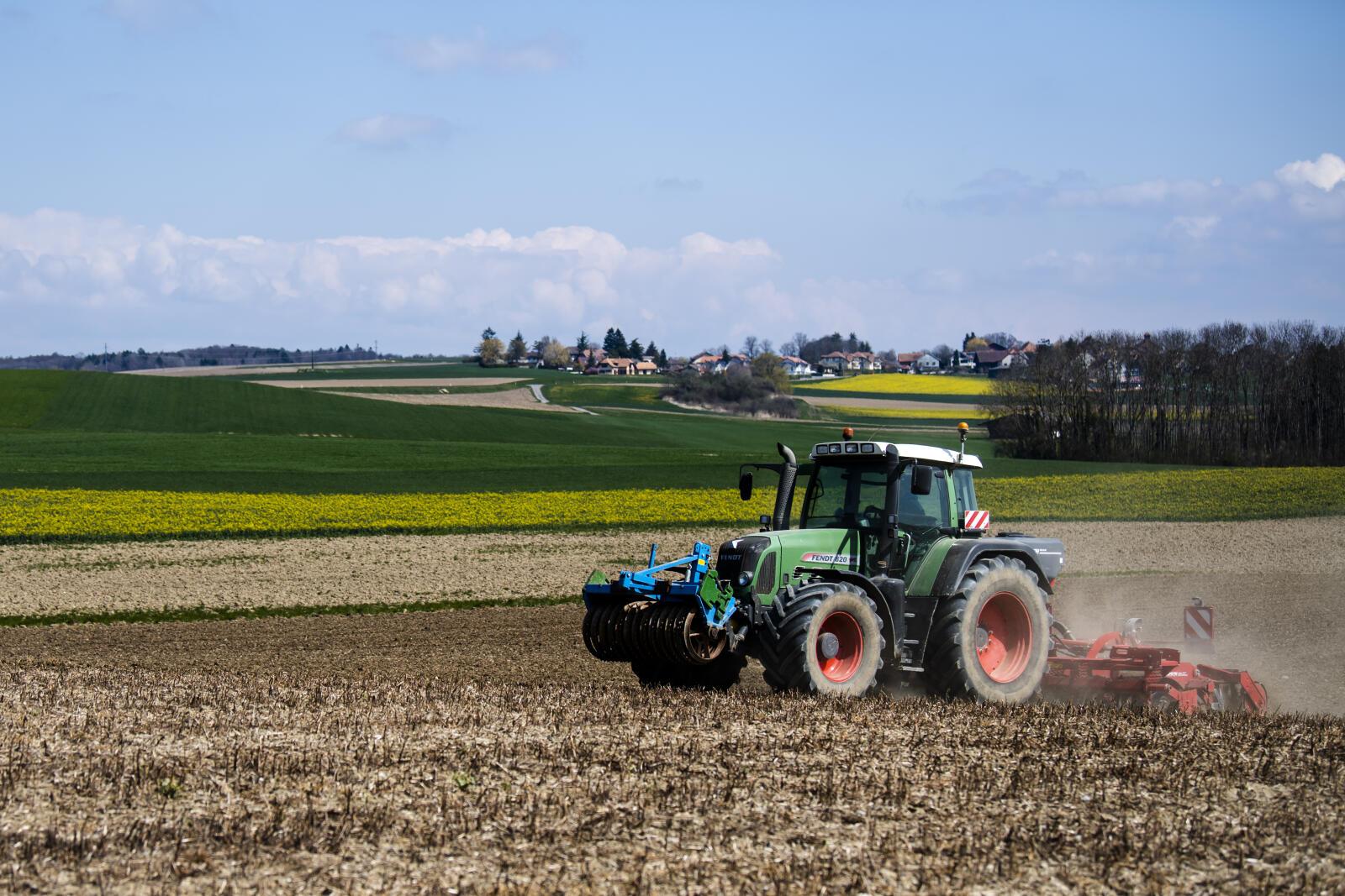 Un agriculteur passe la herse dans un champ avec son tracteur le jeudi 15 avril 2021 a Grancy dans la campagne vaudoise. La population doit voter le 13 juin prochain sur deux initiatives "Pour une eau potable propre et une alimentation saine" et "Pour une Suisse libre de pesticides de synthese". (KEYSTONE/Jean-Christophe Bott)