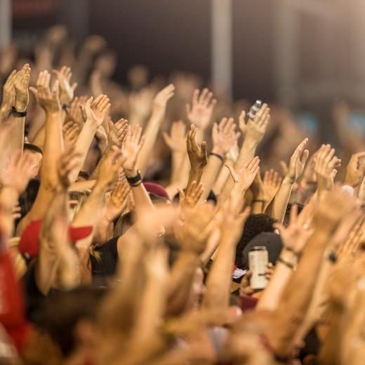 People make noise and clap for the sports team at a loud stadium event