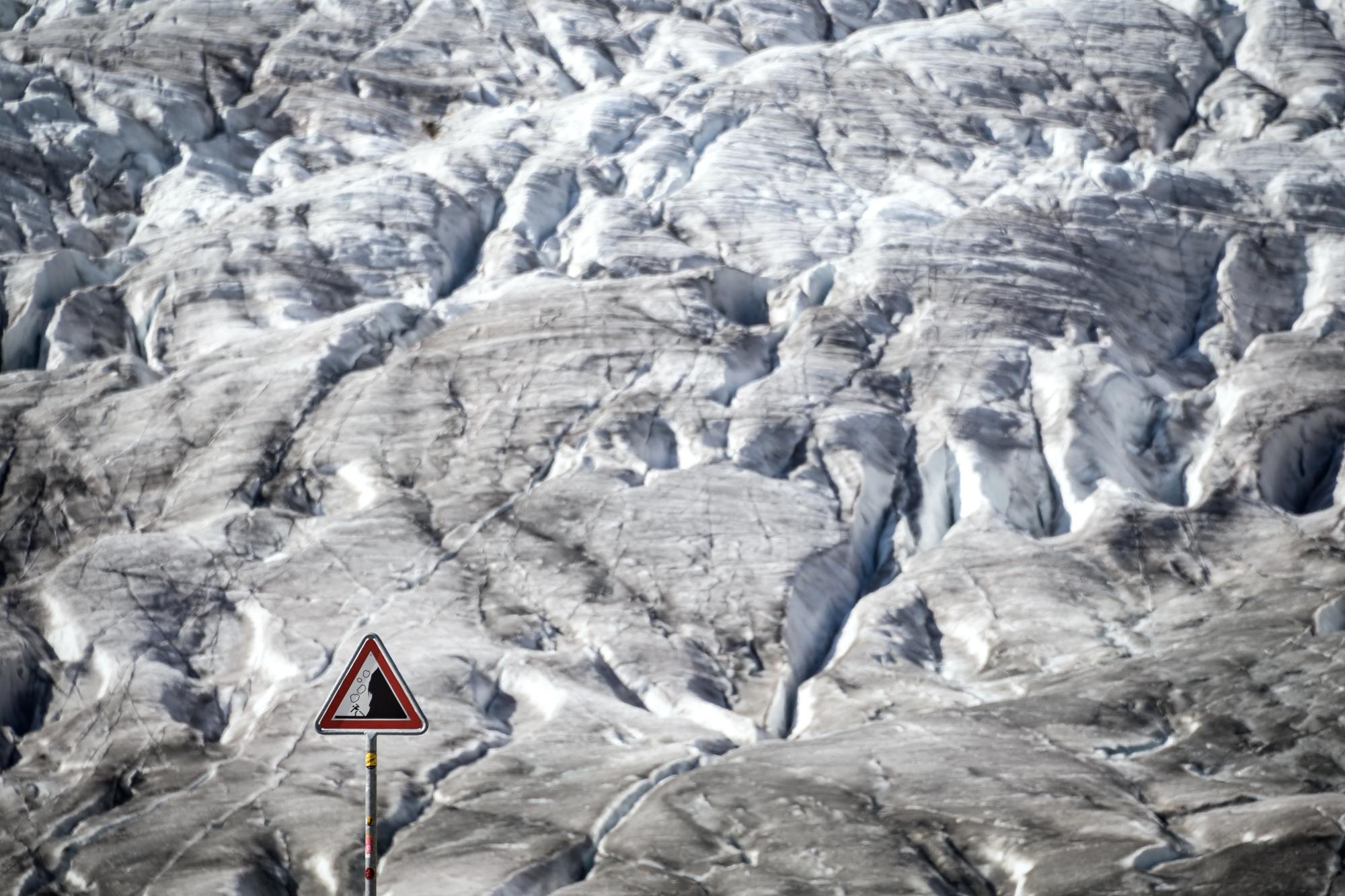 This picture taken on October 01, 2019 shows a warning sign for rockslide next to the Aletsch glacier above Bettmeralp, Swiss Alps. - The mighty Aletsch -- the largest glacier in the Alps -- could completely disappear by the end of this century if nothing is done to rein in climate change, a study showed on September 12, 2019 by ETH technical university in Zurich. (Photo by Fabrice COFFRINI / AFP)