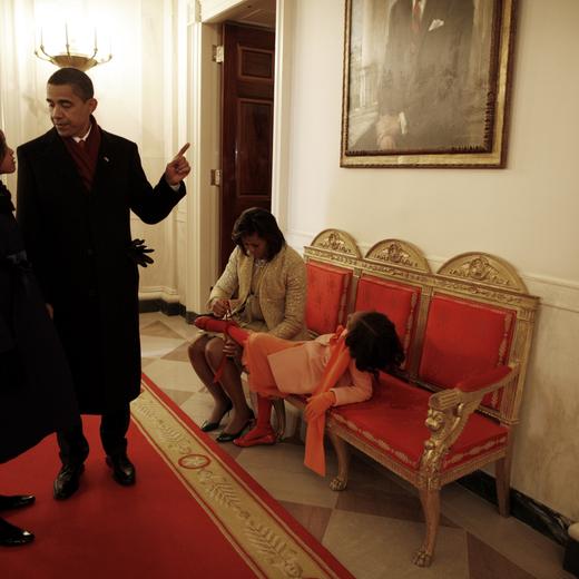 WASHINGTON D.C. - JANUARY 20: The exhausted First Family arrive back at their new home at 1600 Pennsylvania avenue after President Barack Obama was sworn in by Chief Justice John Roberts as the 44th president of the United States on the West Front of the Capitol on January 20, 2009 in Washington, DC. Obama becomes the first African-American to be elected to the office of President in the history of the United States. Here Sasha has her shoes adjusted by her mother after the long day. (Photo by Charles Ommanney/Getty Images)