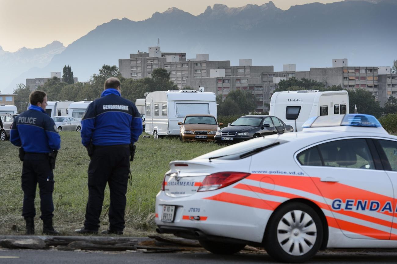 Des policiers de la Police Cantonale Vaudoise observent l'evacuation des caravannes de gens du voyage, gitans, stationnees illegalement dans un champs de l'Etat de Vaud ce vendredi 14 septembre 2012 a Chavannnes-pres-Renens, Vaud. (KEYSTONE/Laurent Gillieron)