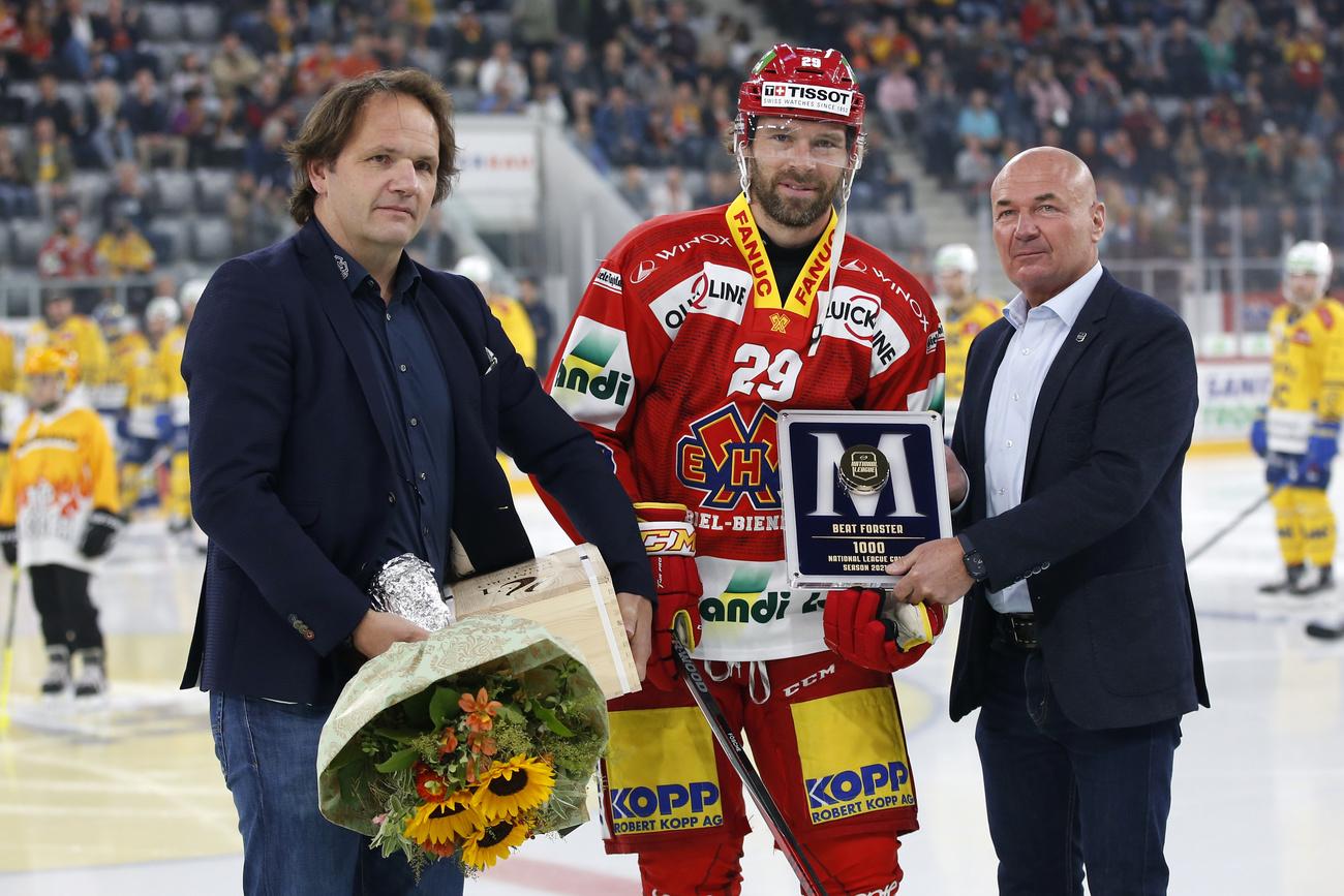 Biels Beat Forster wird vor dem Spiel fuer sein 1000. Spiel in der National League von EHCB General Manager Martin Steinegger, links, und Liga-Direktor Denis Vaucher, rechts, geehrt, vor dem Eishockey Meisterschaftsspiel der National League zwischen EHC Biel und HC Davos, am Samstag, 18. September 2021, in der Tissot Arena in Biel. (KEYSTONE/Peter Klaunzer)
