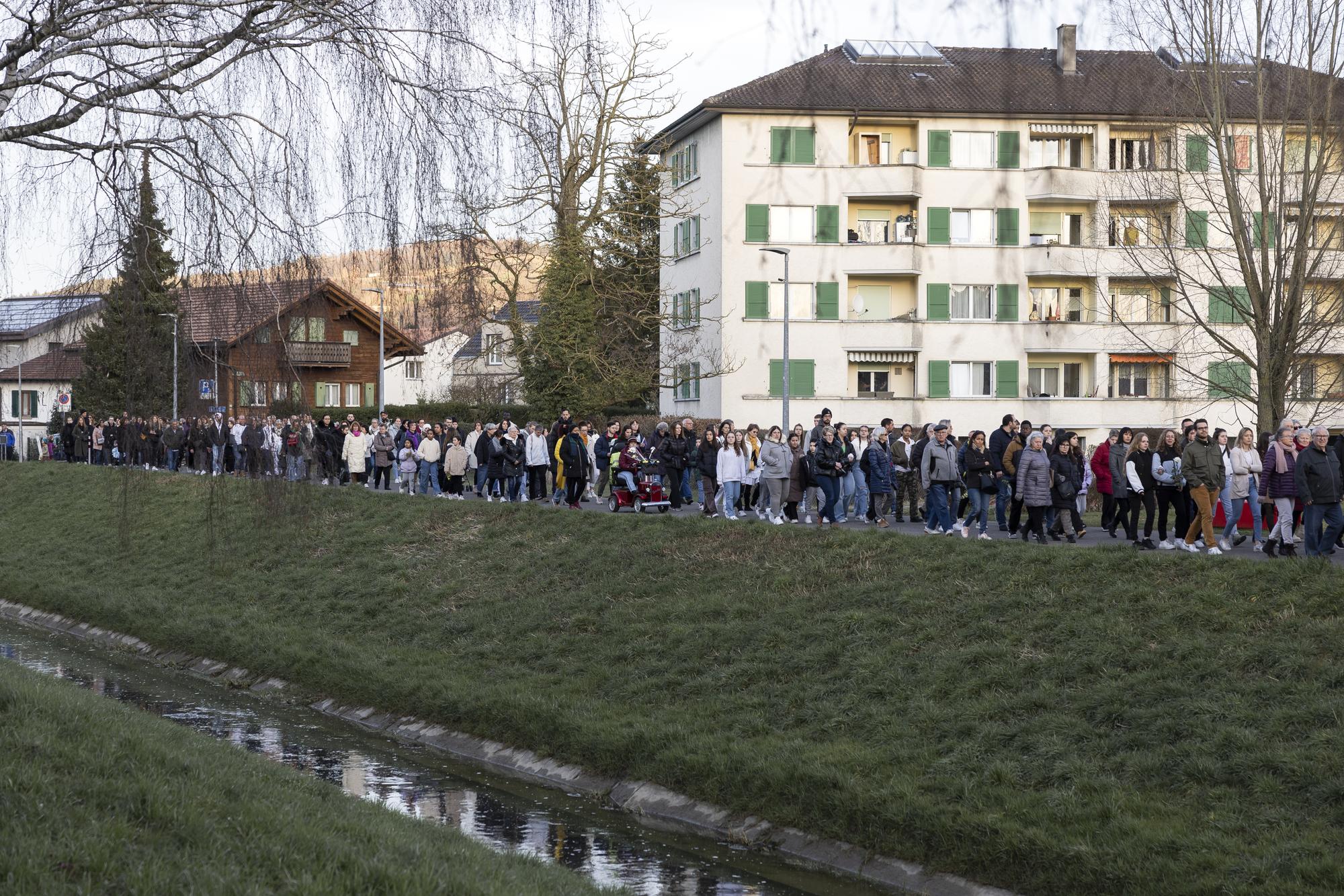 Des personnes marchent dans la rue lors d'une marche blanche ce jeudi, 16 mars 2023 a Yverdon-les-Bains. Suite au drame survenu a la rue du Valentin le 9 mars qui a coute la vie a cinq personnes d?une meme famille, la Municipalite d?Yverdon-les-Bains a invite la population a une marche blanche en hommage aux victimes. (KEYSTONE/Cyril Zingaro)