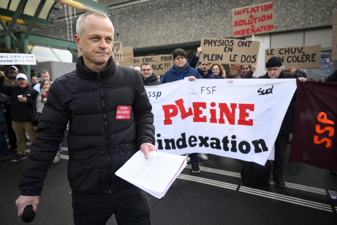 David Gygax, secretaire syndical du Syndicat SSP Vaud parle devant les employes du Centre hospitalier universitaire vaudois, CHUV, brandissent des pancartes lors d'un rassemblement pendant la journee d'actions et de greve de la fonction publique vaudoise, des salaries des secteurs publics a l'appel de leurs syndicats (FSF, SSP, SUD) ce mardi 31 janvier 2023 devant le CHUV a Lausanne. (KEYSTONE/Laurent Gillieron)