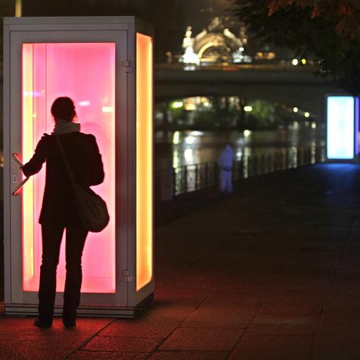 Vue de l'une des 5 installations " Les yeux de la nuit " ici le Quai Turrettini "Talking lights" photographier, ce vendredi 26 octobre 2007. Symboliquement, l'evenement prend place pile a l'epoque du passage a l'heure d'hiver. Au moment ou l'obscurite gagne sur le jour. Pendant une semaine, le quartier de Saint-Gervais, a Geneve, va prendre des allures feeriques a la nuit tombee, grace aux "Yeux de la nuit". La manifestation dediee aux illuminations artistiques, une manifestation ludique et festive, cinq sites beneficie d'une intervention lumineuse et artistique. Tom Groll, artiste (Allemagne) et l'un des curateurs du festival "Glow" a Eindhoven (Pays-Bas).  Deux cabines telephoniques s'illuminent lorsque les visiteurs s'y glissent pour se parler de l'une a l'autre. L'intensite, le rythme et la couleur de la lumiere dependent des modulations et tonalites de la voix, qui sont transformees en frequences lumineuses. (KEYSTONE/Martial Trezzini)
