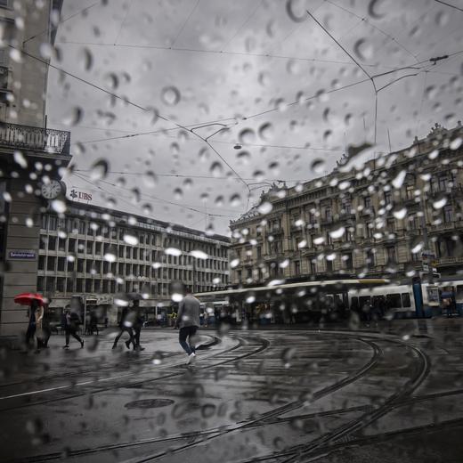 People walk past the headquarters of the Swiss bank Credit Suisse, right, and UBS, left, at the Paradeplatz .in Zurich, Switzerland, on Friday, March 24, 2023. (KEYSTONE/Michael Buholzer).