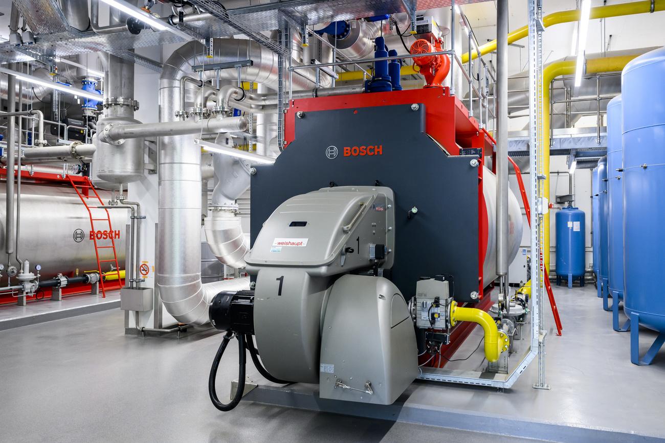 Une vue de la salle des machines avec une chaudiere a gaz dans le batiment de la centrale thermique lors de l'inauguration de la nouvelle centrale thermique de l'EPFL, apres trois ans de travaux le jeudi 8 septembre 2022 a Lausanne. La centrale thermique permettra au campus lausannois de se chauffer et de se refroidir integralement avec l'eau du lac et en exploitant la chaleur dégagee par son centre de donnees. (KEYSTONE/Jean-Christophe Bott)