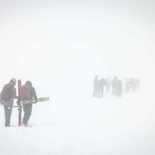 Competitors walking in the fog after competitions are posponed to upcoming days, but not earlier next Tuesday, during the Verbier Xtreme Freeride World Tour (FWT) finals on the "Bec des Rosses" mountain above the alpine resort of Verbier, Switzerland, Saturday, March 25, 2023. (KEYSTONE/Valentin Flauraud)