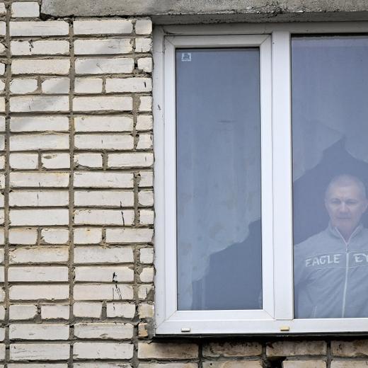 (FILES) In this file photo taken on March 23, 2023 Alexei Moskalyov, 54, a single parent of Maria Moskalyova, the 13-year-old girl who drew a picture critical of Moscow's military campaign in Ukraine at school in April last year, looks out through the window of his flat after he was placed under house for repeating Ukraine posts discrediting the Russian army, in the town of Yefremov in the Tula region. - A Russian court on March 28, 2023 jailed a single father over his comments about Moscow's Ukraine offensive, in a case that was launched after his daughter made a Ukraine-related drawing at school. (Photo by Natalia KOLESNIKOVA / AFP)