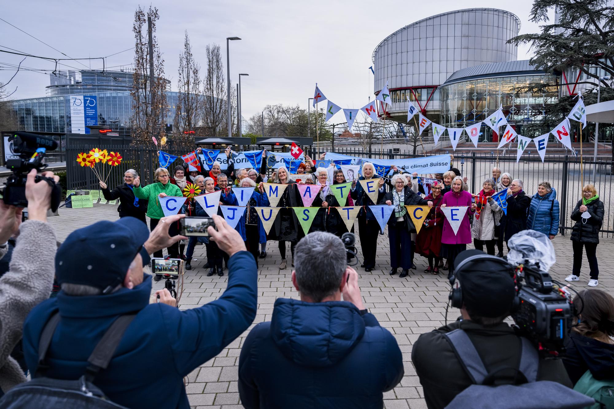 Les Ainees pour la protection du climat (KlimaSeniorinnen) posent ensemble lors d'une audience publique devant la Grande Chambre de la Cour europeenne des droits de l'homme (CEDH) le mercredi 29 mars 2023 a Strasbourg en France. La Cour europeenne des droits de l'homme examine le recours des Ainees suisses pour la protection du climat. Si elle devait entrer en matiere sur le fond, l'affaire pourrait avoir valeur de precedent en matiere de droits humains sur le climat. (KEYSTONE/Jean-Christophe Bott)