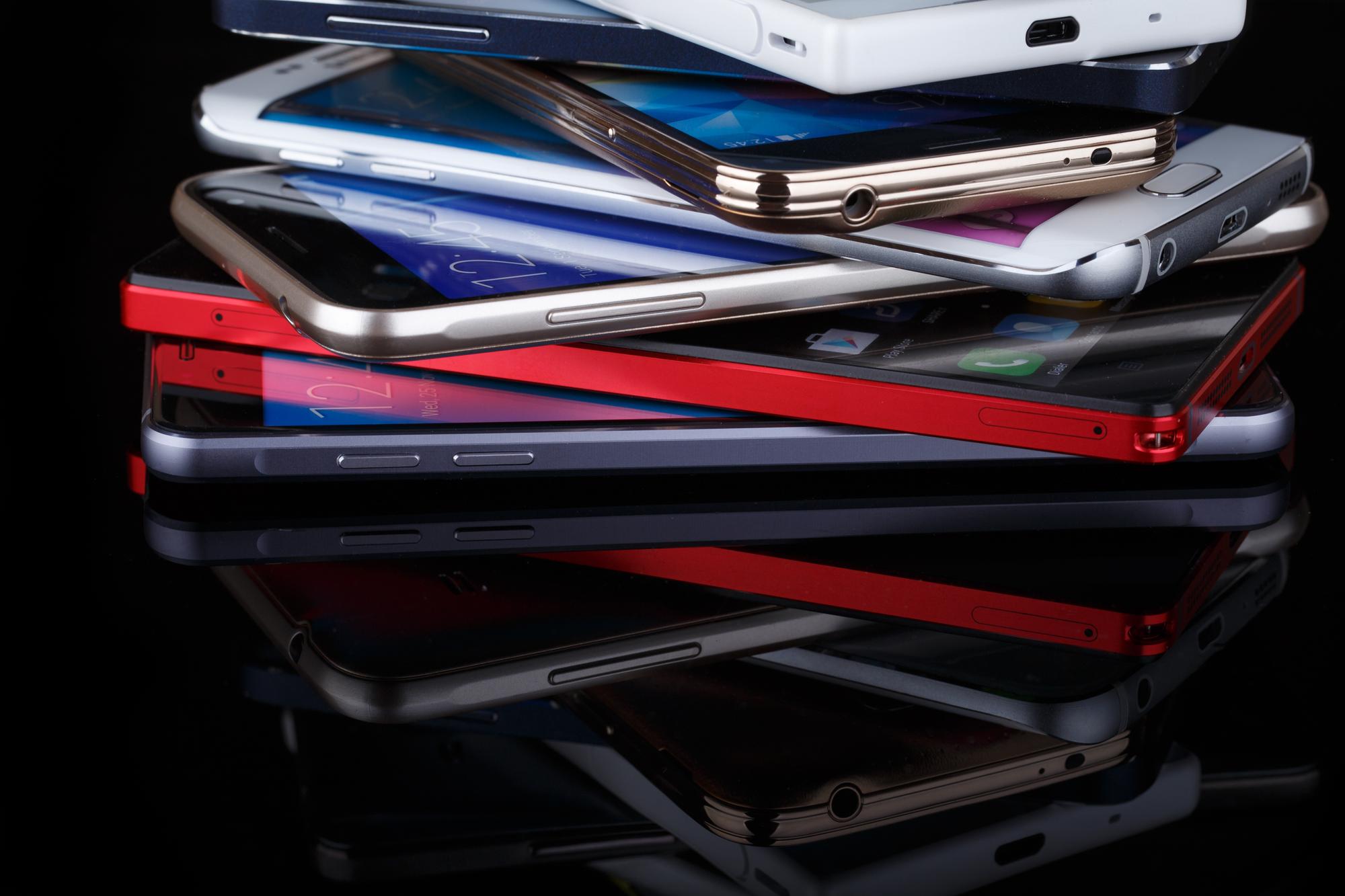 Mobile phone wireless communication technology and mobility business office concept - group of smartphones on black background