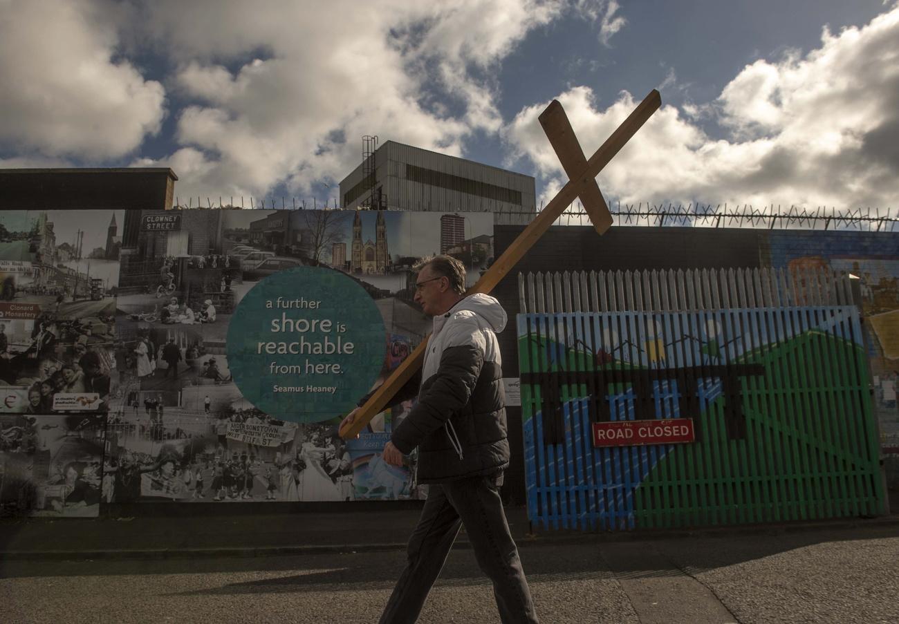 epa10563269 A man walks with a cross as residents from the Falls and Shankill Roads create a Human Peacewall at Northumberland Street to form a line of solidarity between the two communities to mark the 25th anniversary of the Northern Ireland Agreement in Belfast, Northern Ireland, Britain, 7 April 2023. The Good Friday Agreement was signed on 10 April 1998. The agreement ended the violent phase of the political conflict in Northern Ireland and is seen as the major development in the Northern Ireland peace process of the 1990s. EPA/MARK MARLOW