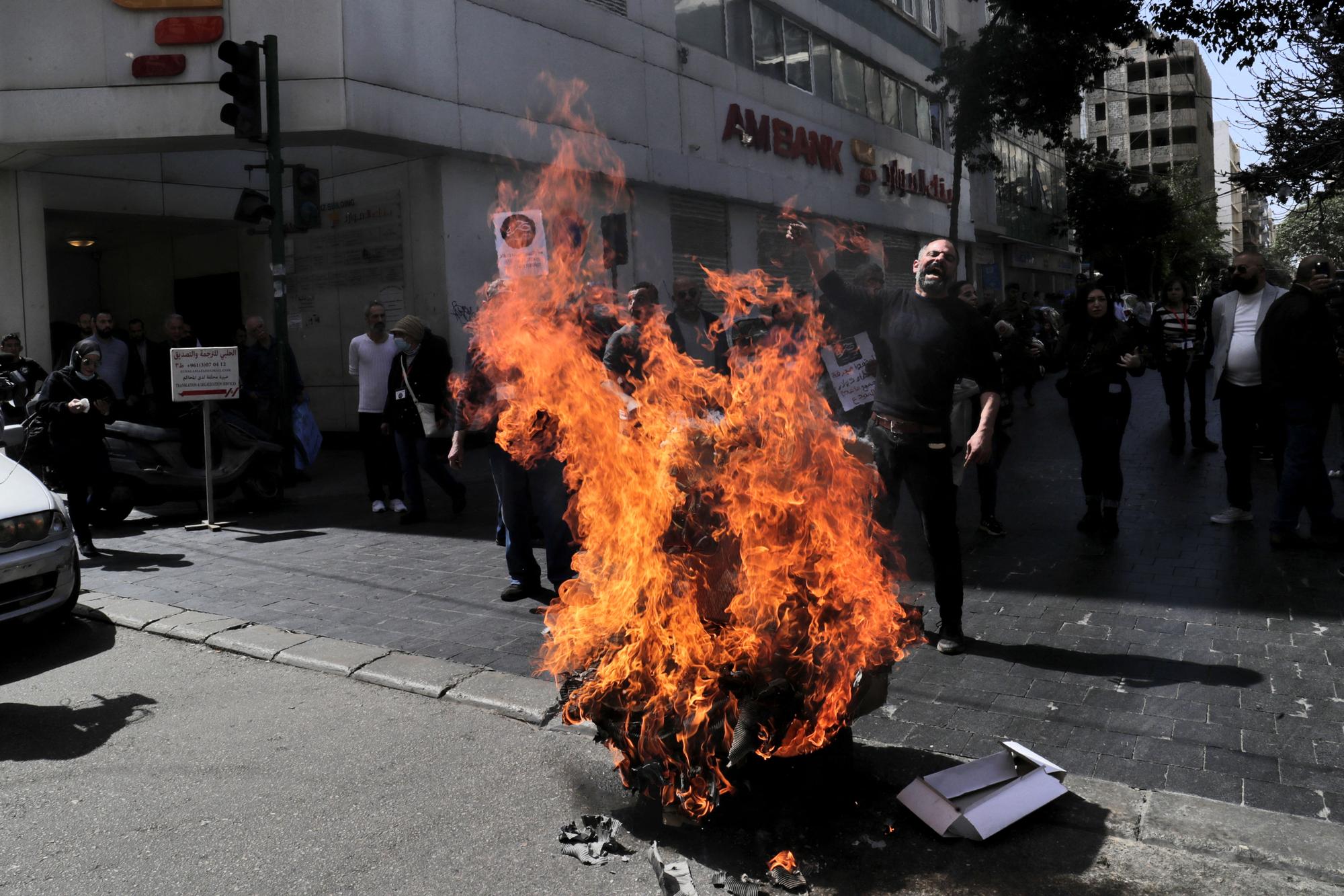 Lebanese protestors burn tyres outside a private bank during a demonstration by members of the banks depositors committee against monetary policies, on March 24, 2023. - Lebanon's economic meltdown, described by the World Bank as one of the worst in recent global history, has plunged most of the population into poverty according to the United Nations. (Photo by ANWAR AMRO / AFP)