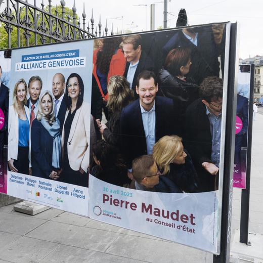 Une personnes passe vers l'affiche electorale du parti Socialiste - Les Verts Carole-Anne Kast / Antonio Hodgers / Fabienne Fischer / Thierry Apotheloz, l'affiche de l'alliance genevoise Delphine Bachmann - UDC / Philippe Morel - MCG / Nathalie Fontanet - PLR / Lionel Dugerdil - UDC / Anne Hiltpold - PLR et l'affiche de Libertes et Justice sociale Pierre Maudet, ce lundi 17 avril 2023 a Geneve. Les citoyens genevois voteront pour l'election du deuxieme tour de l'election du Conseil d'Etat du dimanche 30 avril 2023 (KEYSTONE/Salvatore Di Nolfi)