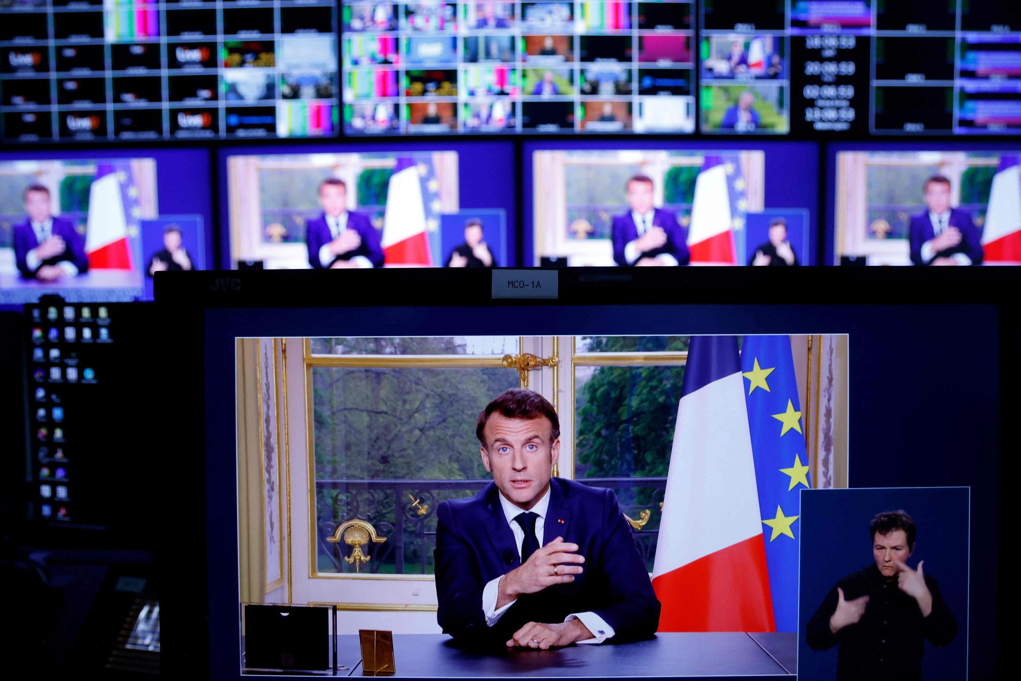 A photo of monitors in a media control room shows French President Emmanuel Macron during a televised address to the nation, made from the Elysee Palace, after signing into law a pensions reform, in Paris, on April 17, 2023. - French President Emmanuel Macron on April 15 addressed France for the first time since signing into law his controversial pension reform, facing warnings the political and social crisis it sparked is not over. Macron signed the legislation just hours after the banner change to raise the retirement age from 62 to 64 had been validated by the constitutional court on April 14, prompting accusations he was smuggling the law through in the dead of night. (Photo by Ludovic MARIN / AFP)