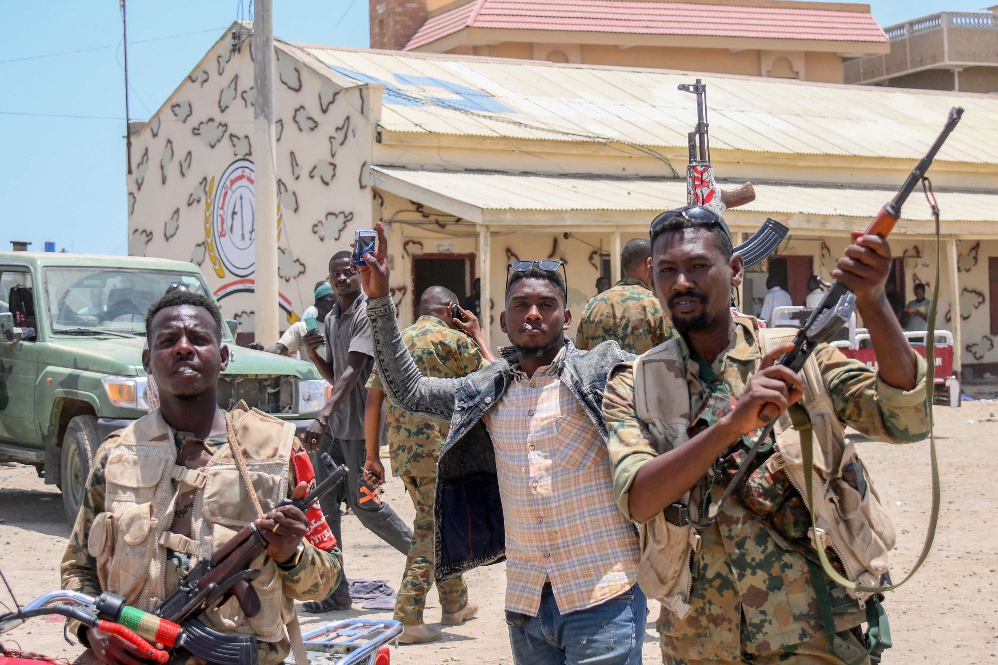 This picture taken on April 16, 2023, shows Sudanese army soldiers, loyal to army chief Abdel Fattah al-Burhan, posing for a picture at the Rapid Support Forces (RSF) base in the Red Sea city of Port Sudan. - Battling fighters in Sudan said they had agreed to an hours-long humanitarian pause, including to evacuate wounded, on the second day of raging urban battles that killed more than 50 civilians including three UN staff and sparking international outcry. (Photo by AFP)