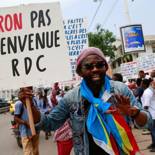 A demonstrator holds a sign that reads "Macron not welcomed in DRC", during a a sit-in to protest against the visit of the French President Emmanuel Macron and France's perceived support for neighbouring Rwanda, which Congo accuses of supporting M23 rebels in the east, in front of the French embassy in Kinshasa, Democratic Republic of Congo March 1, 2023. REUTERS/Justin Makangara