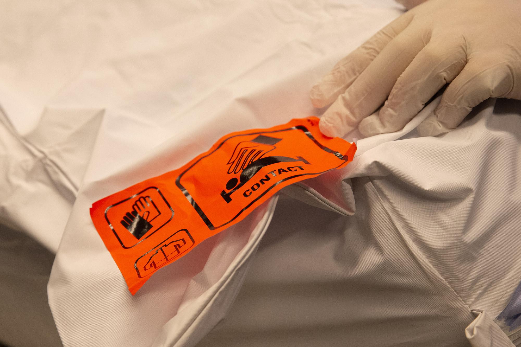 Un employe des pompes funebres va prepare un corps dans le centre funeraire du cimetiere des Rois, ce vendredi 20 novembre 2020 a Geneve. Le service des pompes funebres de la Ville de Geneve ne sait plus ou donner de la tete a cause de la crise sanitaire. Les places dans les chambres froides des cimetieres de Saint-Georges et des Rois sont toutes occupees et des corps ont du etre transferes a la morgue des Hopitaux universitaires de Geneve (HUG). (KEYSTONE/Salvatore Di Nolfi)