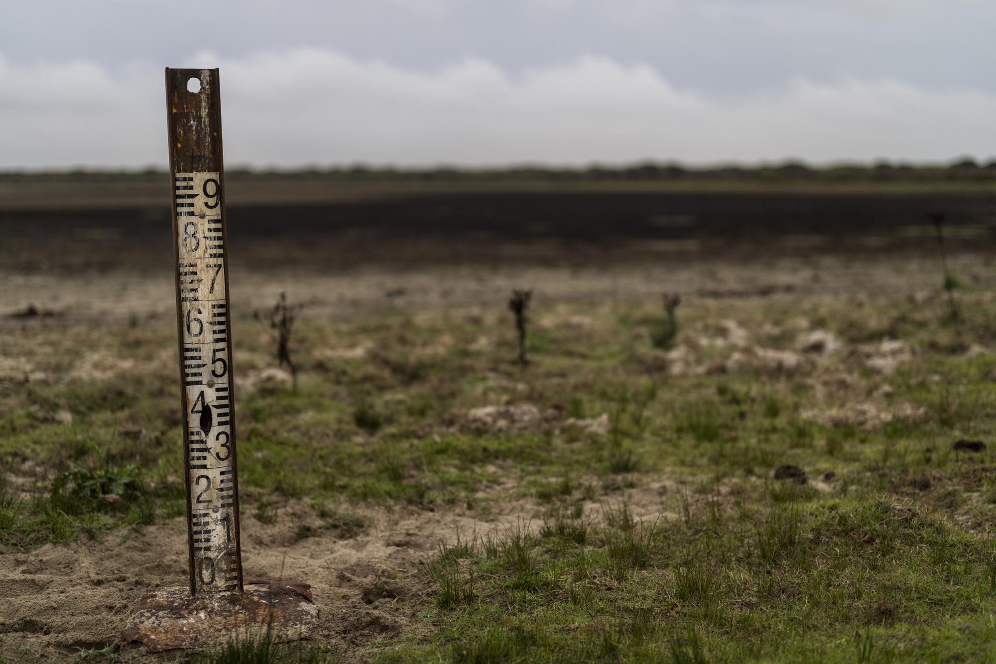 FILE - A water meter stands in a dry wetland in Donana natural park, southwest Spain, on Oct. 19, 2022. Spain's Prime Minister and the European Union's Environment Commissioner on Thursday April 20, 2023 slammed an "illegal" plan by right-wing lawmakers to expand water rights for farmland around some of Europe's most important wetlands amid a prolonged drought. The bill's critics say this would effectively offer an amnesty to farmers already using illegal wells to tap into the Donana aquifer to grow berries for export across Europe. (AP Photo/Bernat Armangue, File)