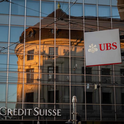 (FILES) A sign of Swiss bank giant UBS bank is seen next to a sign of Credit Suisse baking in Basel, on April 4, 2023 on the eve of the general meeting of shareholders following the takeover by UBS of Credit Suisse hastily arranged by the Swiss government on March 19, 2023 to prevent a financial meltdown. - UBS shares dropped by nearly five percent on on April 25, 2023 after posting a first quarter net profit of $1.0 billion, which was below expectations as it prepares to complete the takeover of Credit Suisse. (Photo by Fabrice COFFRINI / AFP)