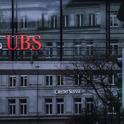 FILE - A traffic light signals green in front of the logos of the Swiss banks Credit Suisse and UBS in Zurich, Switzerland, on March 19, 2023. Swiss banking giant UBS said Tuesday it took in $28 billion of net new money for its wealth management business in the first quarter, with $7 billion of that coming in the days after the announcement of its government-backed takeover of ailing rival Credit Suisse. (Michael Buholzer/Keystone via AP, File)